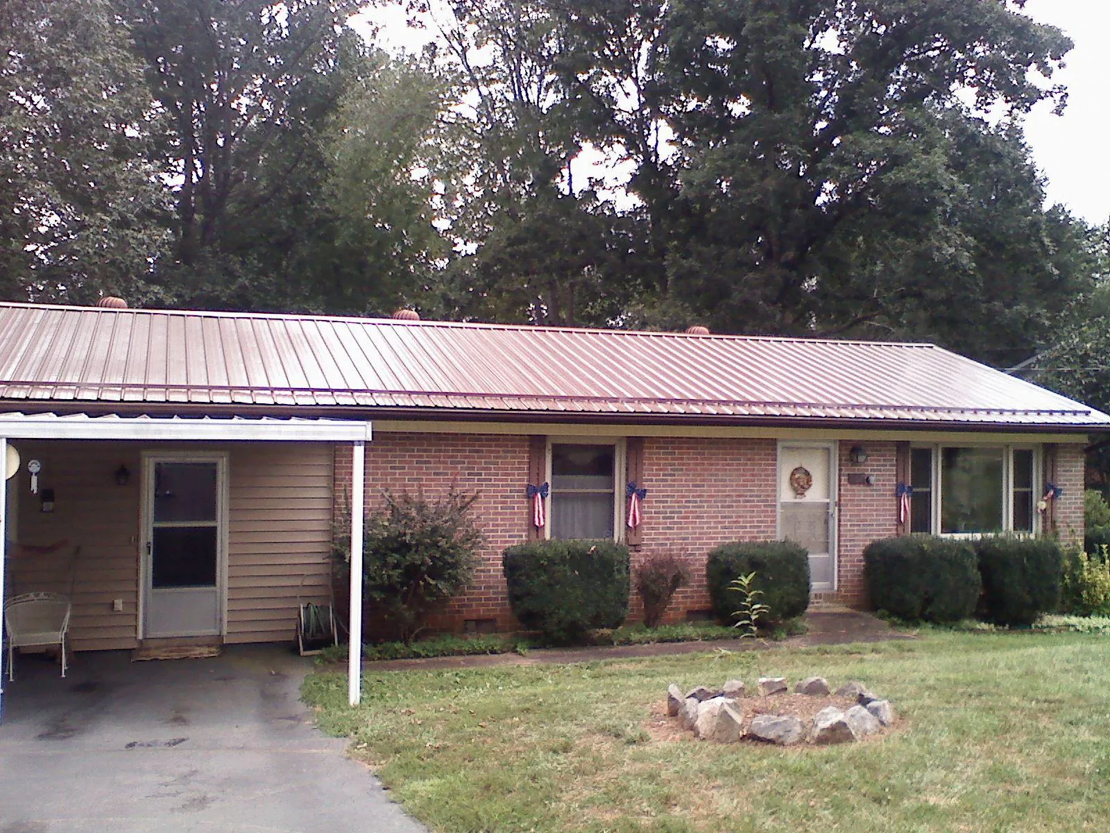 Bronze metal roof and carport on a brick ranch home — Roof Repair work by our crew in Centreville